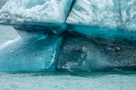 Crystal iceberg in front of Columbia glacier under the clouds, Alaska