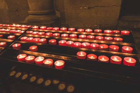 Church candles in red transparent chandeliersの写真素材