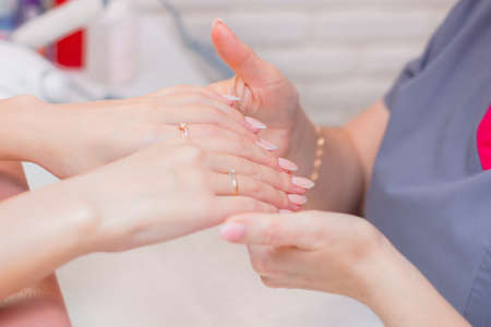 Manicure and nail care master working with client in beauty studio withの写真素材