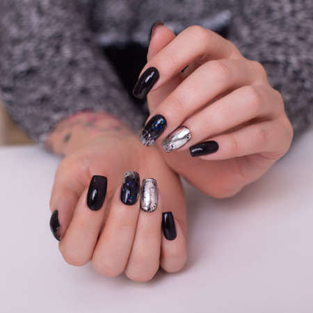 Beautiful female hands with fashion manicure nails, black gel polishの写真素材