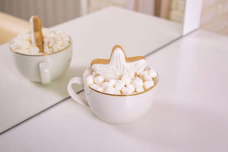 White cup with marshmallow and ginger cake in shape of starの写真素材