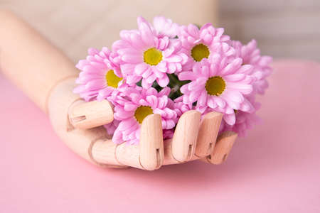 Wooden hand holding beautiful bouquet of violet flowersの写真素材