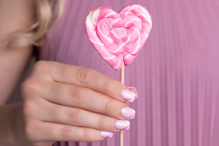 Beautiful female hands with pink and white manicure nails, sparkling french designの写真素材