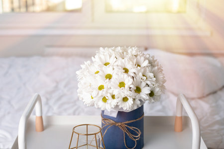 Beautiful bouquet of chamomile flowers on bed backgroundの写真素材