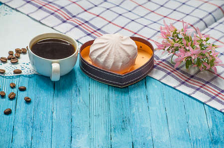 Cooked black coffee with sweet marshmallow on a blue wooden tableの写真素材
