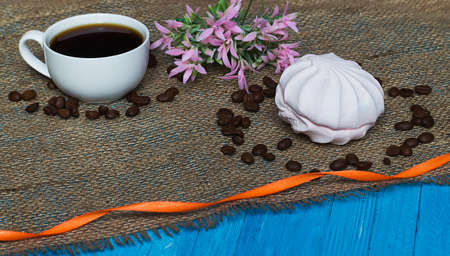 Cooked black coffee with sweet marshmallow on a blue wooden tableの写真素材