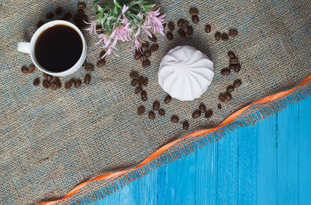 Cooked black coffee with sweet marshmallow on a blue wooden tableの写真素材