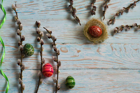 Bouquet willow branch and Easter eggs on a wooden table for a festive moodの写真素材