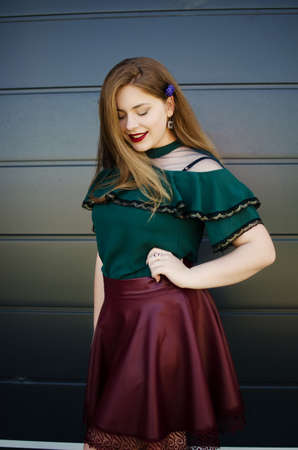 A beautiful happy girl wearing a dark green blouse in springの写真素材