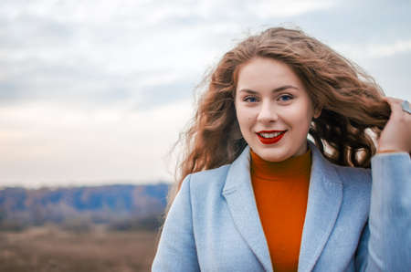 Young smiling girl with curly hair on the background