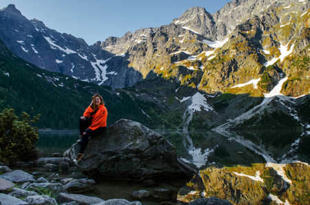 A young girl loves to travel and conquer the peaks of the mountains, she is happyの写真素材
