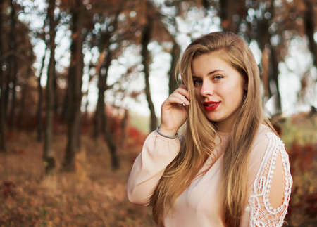 Happy young girl in autumn on background of autumn leavesの写真素材