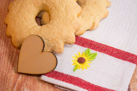 Sweet cookies and a wooden heart on the table