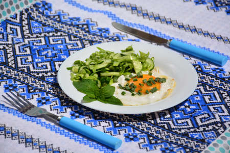 Appetizing scrambled eggs with cabbage salad on a white plateの写真素材