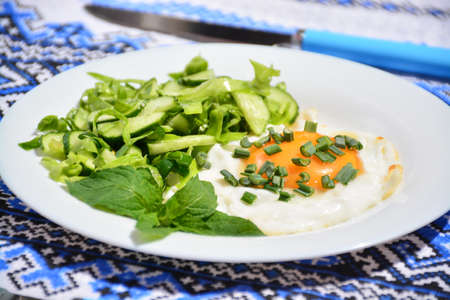 Appetizing scrambled eggs with cabbage salad on a white plateの写真素材