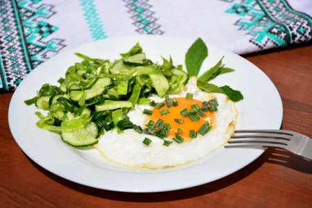 Appetizing scrambled eggs with cabbage salad on a white plateの写真素材