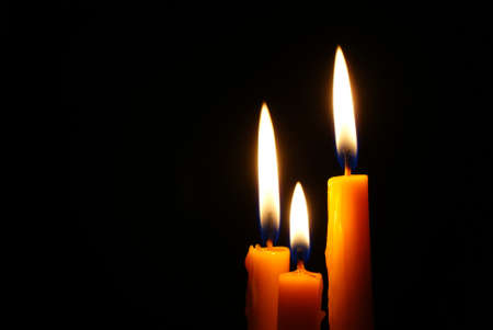 Closeup of burning candle isolated on black backgroundの写真素材