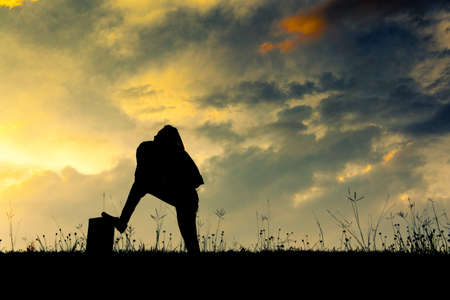 The siluette of young women against a background of sunriseの写真素材