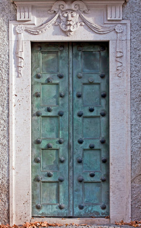 Antique bronze portal decorated with shells and surmounted by a marble maskのeditorial素材