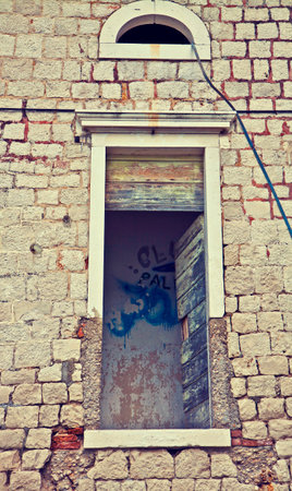 Window detail of a ruined and abandoned building with graffiti insideのeditorial素材
