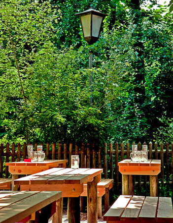 Munich, Germany - beer garden in a quiet moment at the end of a business day with empty beer glasses on wooden benchesのeditorial素材