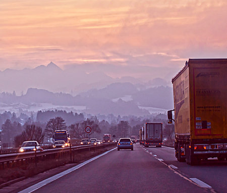 Salzburg, Austria- High traffic as usual on the highway to Munich in a cold winter sunset with snow covering the mountainsのeditorial素材