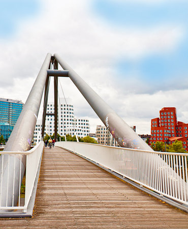 Dusseldorf, Germany - pedestrian bridge on Rhine river with the view of the Neuer Zollhof,  landmark of Media Harbor, with the leaning towersのeditorial素材