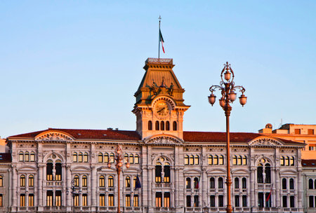 Trieste, Italy - Unity of Italy Square, architectural detail of City Hall at sunset with tower, clock ,quarter bell and street lampのeditorial素材