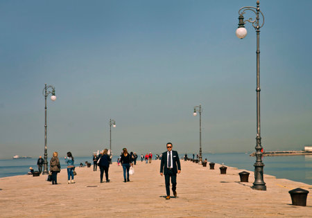 Trieste, Italy - people take a walk on Molo Audace pier in Trieste . Molo Audace former Molo S. Carlo is a very popular sea promenade in city center.のeditorial素材