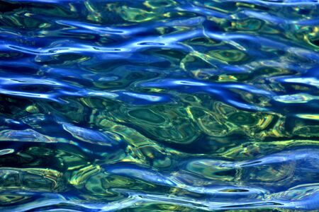Nature background; sunlight reflection on  blue and green sea water surface