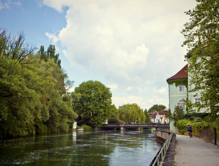 Landshut, Germany - romantic view of the pedestrian walk along the Isar river with lush vegetation and the characteristic Renaissance housesの写真素材