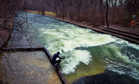 Munich, English Garden - solitary surfer prepares to surf the Eisbach river in a freezing February morning with temperature below 0 (32 F)のeditorial素材