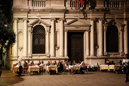 Summer night in Venice, people eat outside at restaurant in a small square against a beautiful classical palaceのeditorial素材