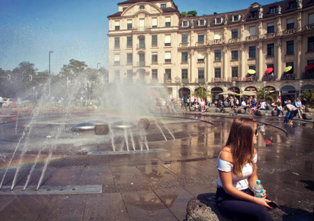 Hot summer  in Munich, more than 30 Celsius,  young woman looks for refreshment near the fountain at Karlsplatz-Stachusのeditorial素材
