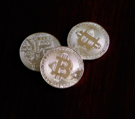  Bitcoins on a dark wooden desk                   
