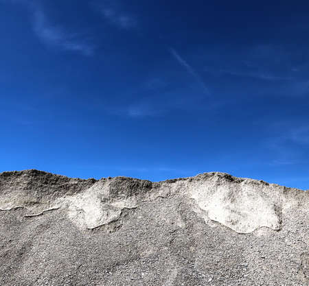 Dunes of gravel for the construction industry against a blue sky