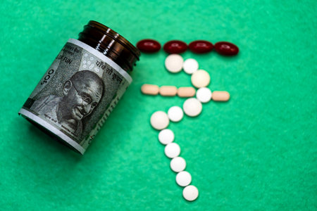 This stock photo shows a bottle of medicine with Indian 500 rupees notes and pills outside. The...