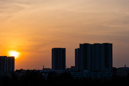 This image is about A golden hour large building view with tree, Stock photo, yellow Sunの写真素材