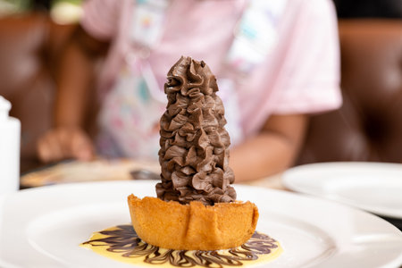 This image is about Cone chocolate bottom waffles and plate filled with white cream background small girl waiting to eatの写真素材