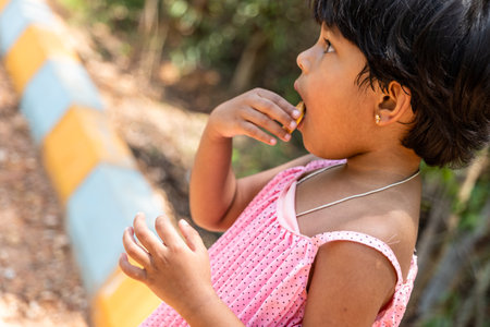 Child licking deliciousness of a cream-filled biscuit, relishing every lick with pure delight.の写真素材