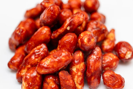 A close-up of a single Milagai mittai, a traditional Indian chili candy, on a white backgroundの写真素材