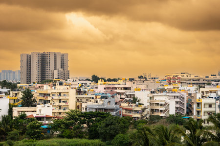 This long shot photo captures a beautiful Indian cityscape with a vibrant orange sky. The city is filled with a variety of traditional Indian buildings,の写真素材