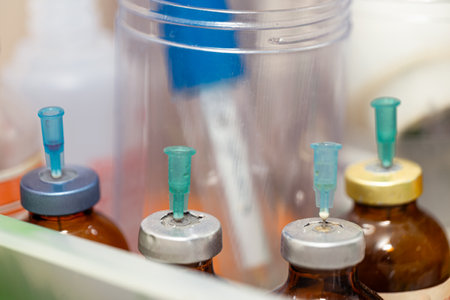 This stock image shows a needle injecting medicine into a bottle
