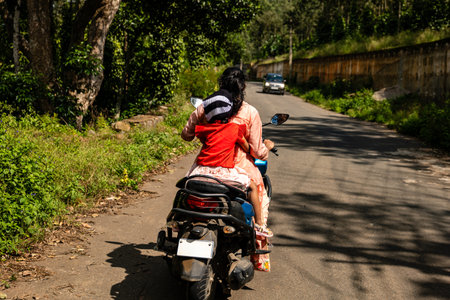 A split-second decision unfolds as a mother instinctively protects her daughter on a scooterの写真素材