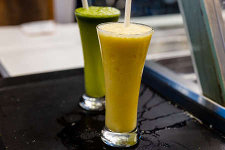 A tall glass filled with refreshing pineapple juice, glistening with condensation and topped with a...
