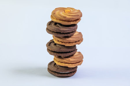 Chocolate cream cookies stacked on top of each other on white background
