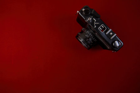 Top view of retro camera on red background with copy space. Flat lay