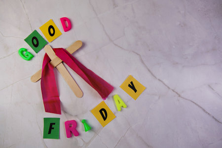 Wooden Cross and spelling the word good Friday on a white backgroundの写真素材
