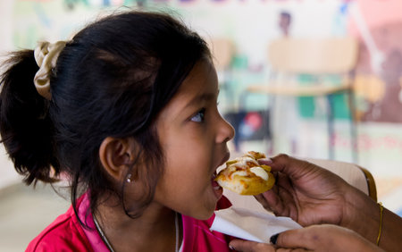 Young girl eating pizza in the restaurant. Selective focus. and mom feeding pizza