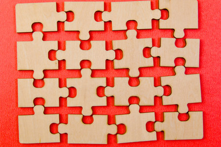 Close up of a group of wooden puzzle pieces on red background.の写真素材